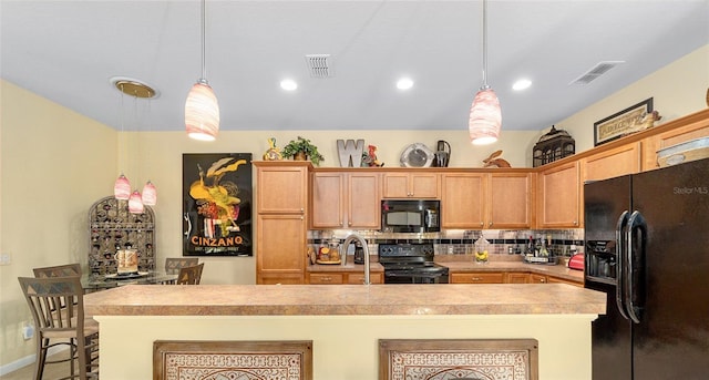 kitchen with visible vents, hanging light fixtures, light countertops, backsplash, and black appliances