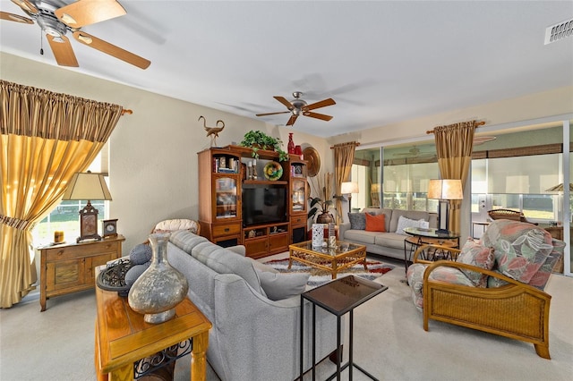 living room with visible vents, ceiling fan, and a wealth of natural light