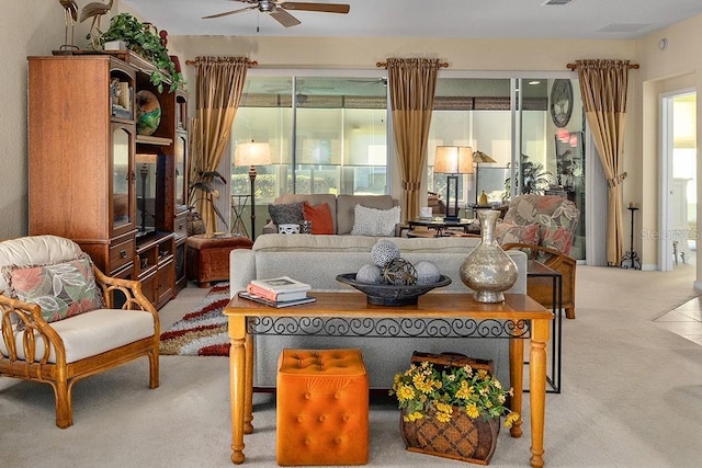 living room featuring plenty of natural light, visible vents, ceiling fan, and light colored carpet