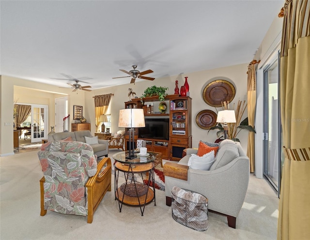 living area featuring light carpet and ceiling fan