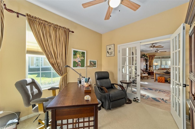 home office with baseboards, french doors, a ceiling fan, and light colored carpet