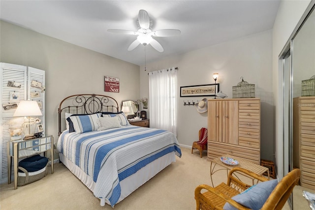 bedroom with ceiling fan, baseboards, a closet, and light colored carpet