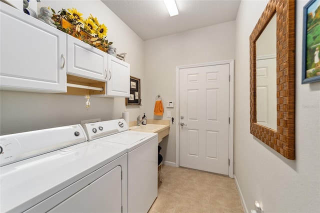 washroom with light tile patterned floors, washer and clothes dryer, cabinet space, and baseboards