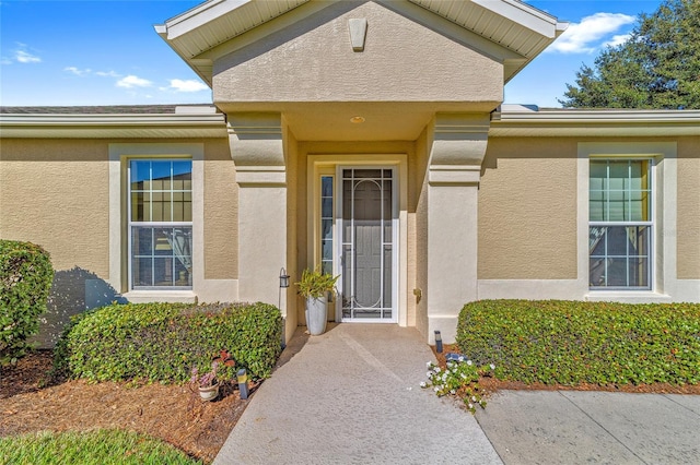 doorway to property featuring stucco siding