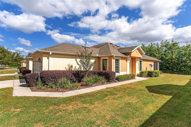 view of front of home with a front lawn and a garage