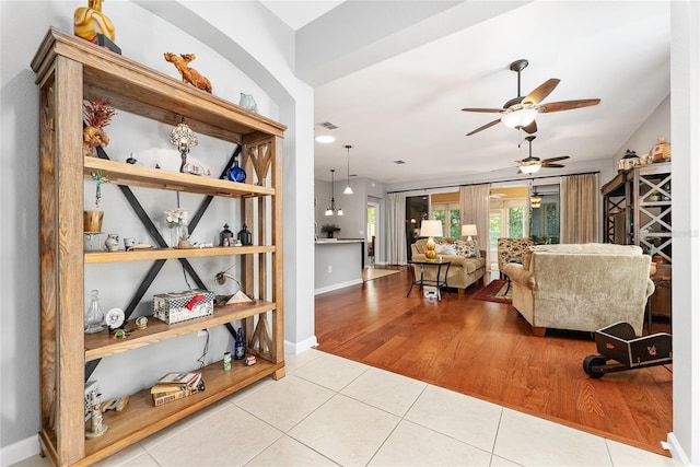 living room featuring light hardwood / wood-style floors and ceiling fan