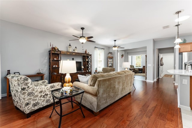 living room with ceiling fan and dark hardwood / wood-style flooring