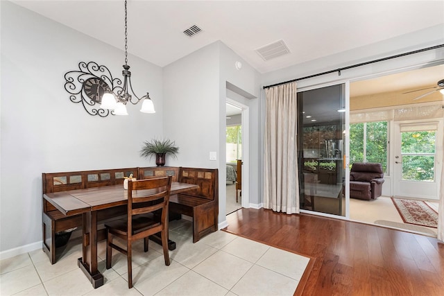 dining area featuring ceiling fan with notable chandelier, light hardwood / wood-style flooring, and a wealth of natural light