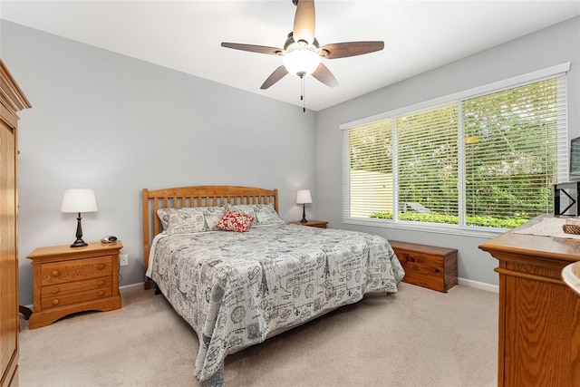 bedroom with ceiling fan and light carpet