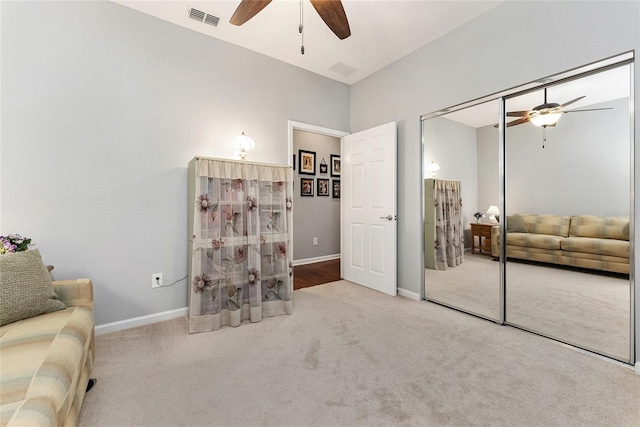 living area with light colored carpet and ceiling fan