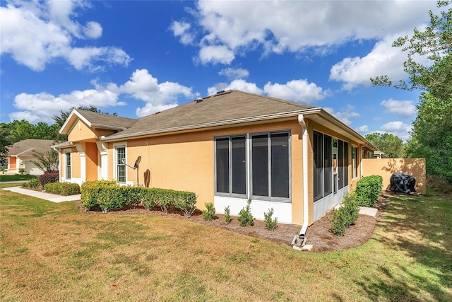 view of property exterior with a lawn and a sunroom