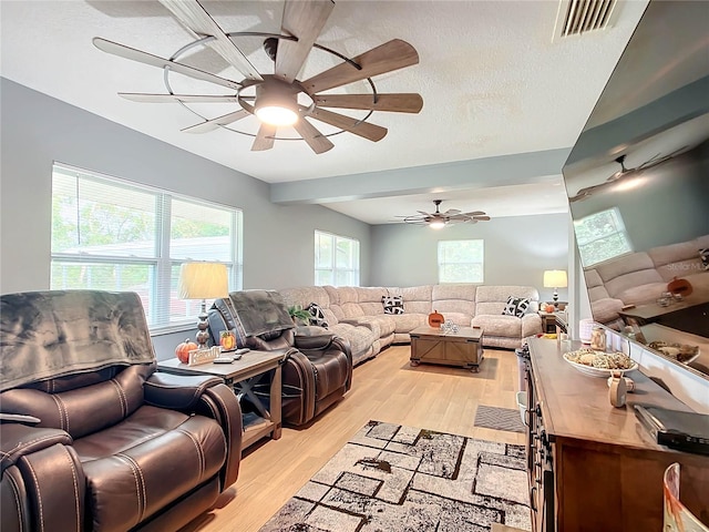 living room with a textured ceiling and light wood-type flooring