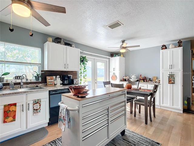 kitchen featuring french doors, white cabinets, stainless steel dishwasher, and sink