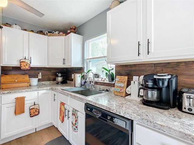 kitchen with sink, black dishwasher, decorative backsplash, white cabinets, and light wood-type flooring