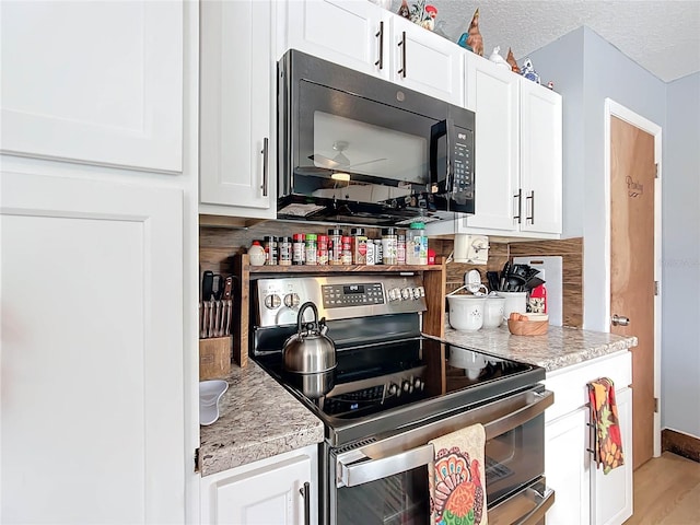 kitchen with backsplash, a textured ceiling, light hardwood / wood-style floors, white cabinetry, and stainless steel range with electric cooktop