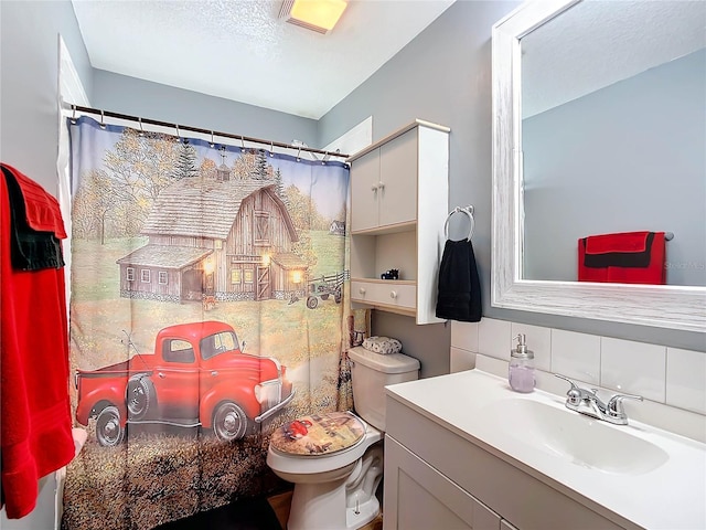 bathroom with decorative backsplash, toilet, a textured ceiling, and vanity