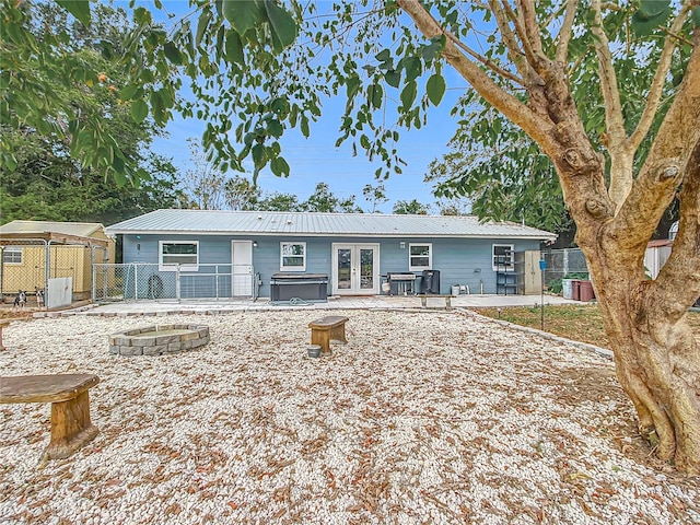 view of front of home featuring a patio area, central air condition unit, an outdoor fire pit, and french doors