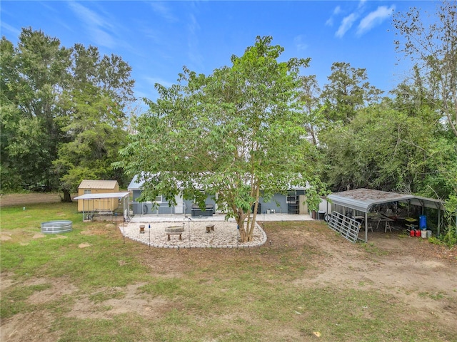 view of yard featuring a carport and an outdoor structure