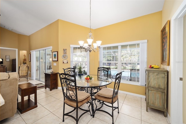 dining space with light tile patterned floors, a chandelier, visible vents, baseboards, and vaulted ceiling