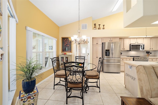 dining area with light tile patterned floors, visible vents, a chandelier, and high vaulted ceiling