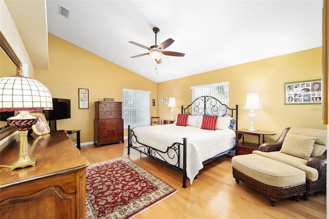 bedroom with lofted ceiling, visible vents, light wood-style flooring, a ceiling fan, and baseboards