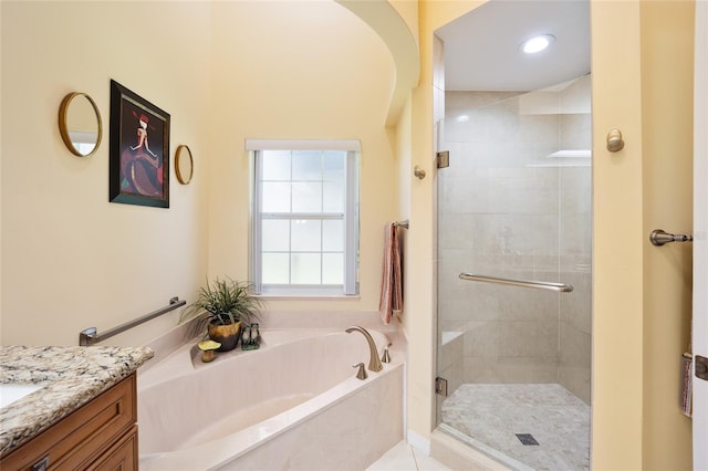 bathroom with a garden tub, a shower stall, and vanity