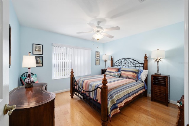 bedroom featuring ceiling fan, light wood-style flooring, and baseboards