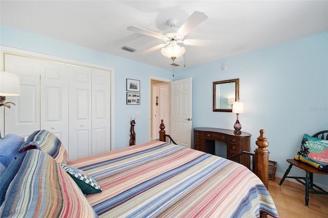 bedroom featuring light wood-style floors, a closet, visible vents, and a ceiling fan