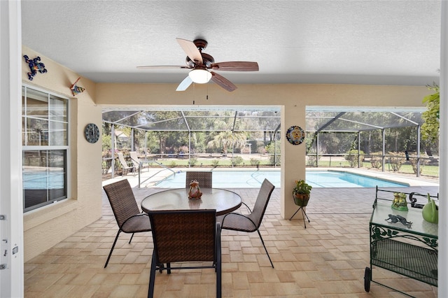 sunroom featuring a ceiling fan and a swimming pool