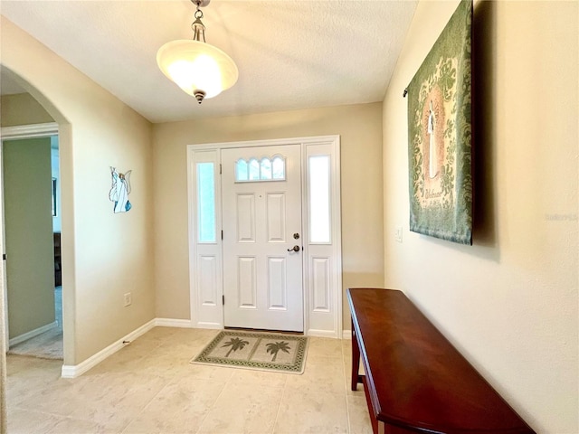 tiled entrance foyer with a textured ceiling