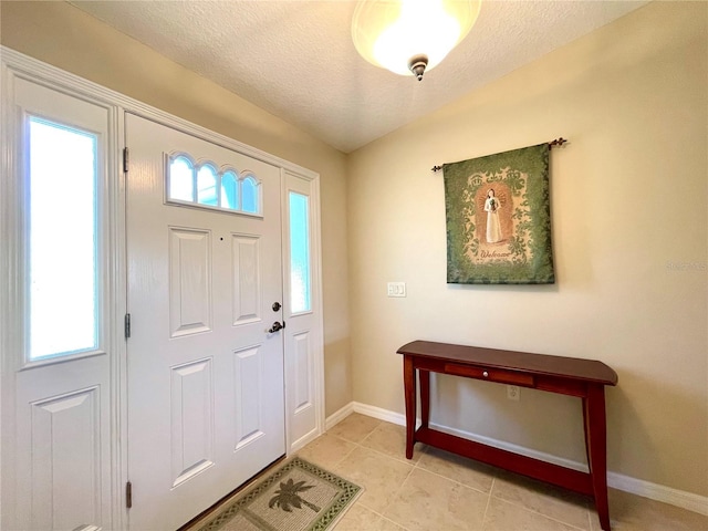 tiled foyer with a textured ceiling