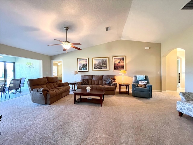 carpeted living room with a textured ceiling, ceiling fan, and vaulted ceiling