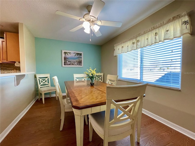 dining area featuring dark hardwood / wood-style floors, ceiling fan, and a textured ceiling