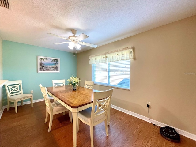 dining area with a textured ceiling, ceiling fan, and dark wood-type flooring