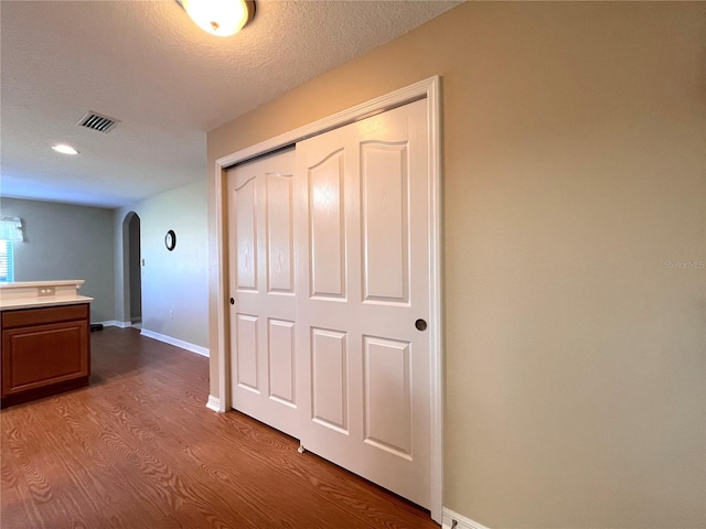 corridor featuring hardwood / wood-style floors and a textured ceiling