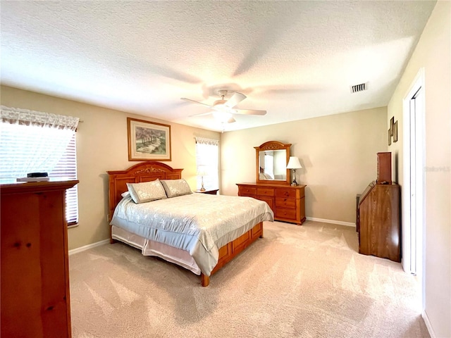 carpeted bedroom with ceiling fan and a textured ceiling