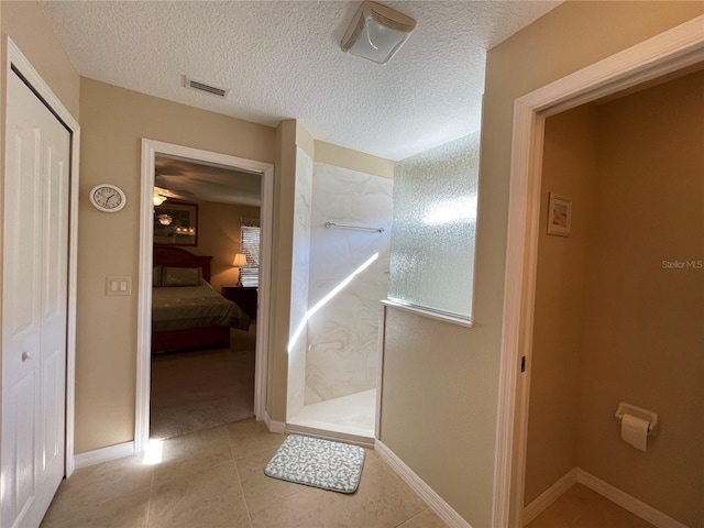 bathroom featuring tile patterned flooring and a textured ceiling