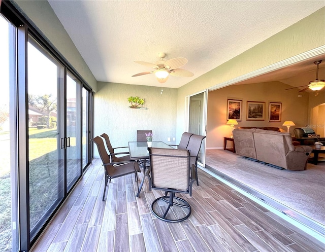 sunroom with ceiling fan and vaulted ceiling