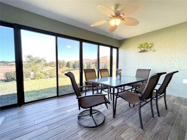 dining space with a textured ceiling, hardwood / wood-style flooring, a wealth of natural light, and ceiling fan