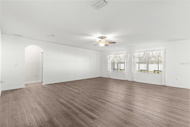 empty room featuring a textured ceiling, ceiling fan, and dark hardwood / wood-style floors