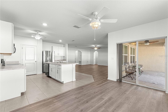 kitchen featuring stainless steel appliances, sink, a center island with sink, light hardwood / wood-style flooring, and white cabinets