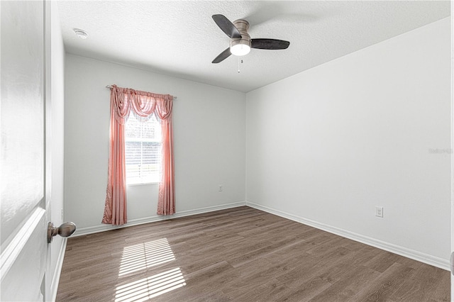 spare room with a textured ceiling, hardwood / wood-style flooring, and ceiling fan