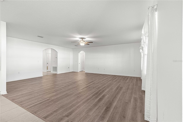 unfurnished living room with hardwood / wood-style floors, ceiling fan, and a textured ceiling