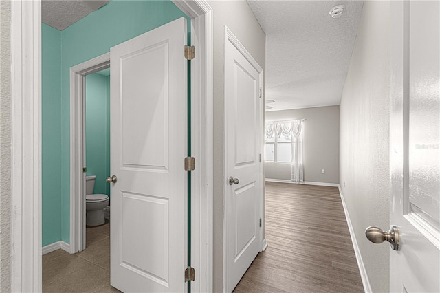 hallway featuring a textured ceiling and light hardwood / wood-style flooring