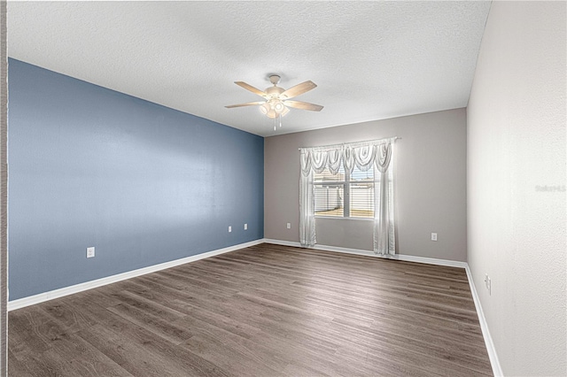 empty room featuring a textured ceiling, dark hardwood / wood-style floors, and ceiling fan