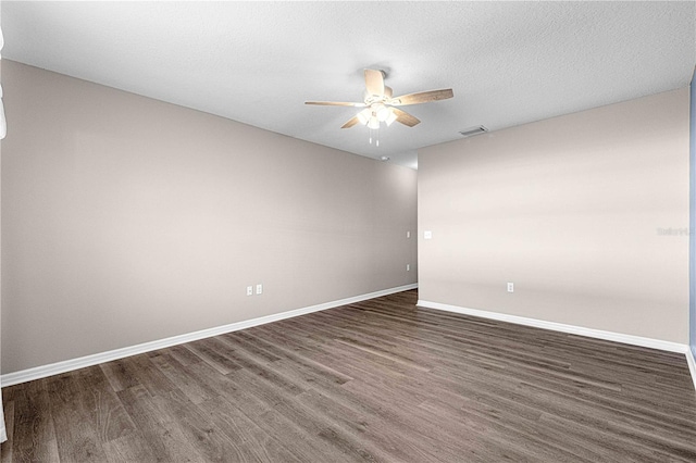 empty room featuring a textured ceiling and dark wood-type flooring