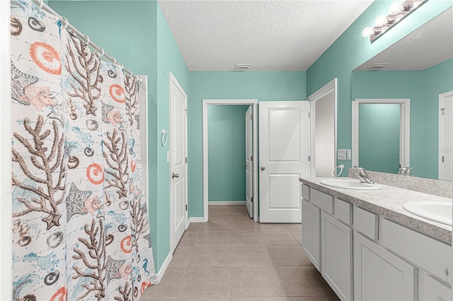 bathroom featuring tile patterned flooring, vanity, a textured ceiling, and a shower with shower curtain