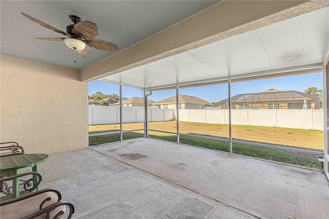 unfurnished sunroom with ceiling fan