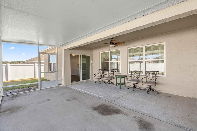 unfurnished sunroom with ceiling fan