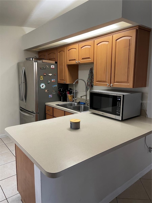 kitchen featuring light tile patterned flooring, stainless steel appliances, kitchen peninsula, and sink